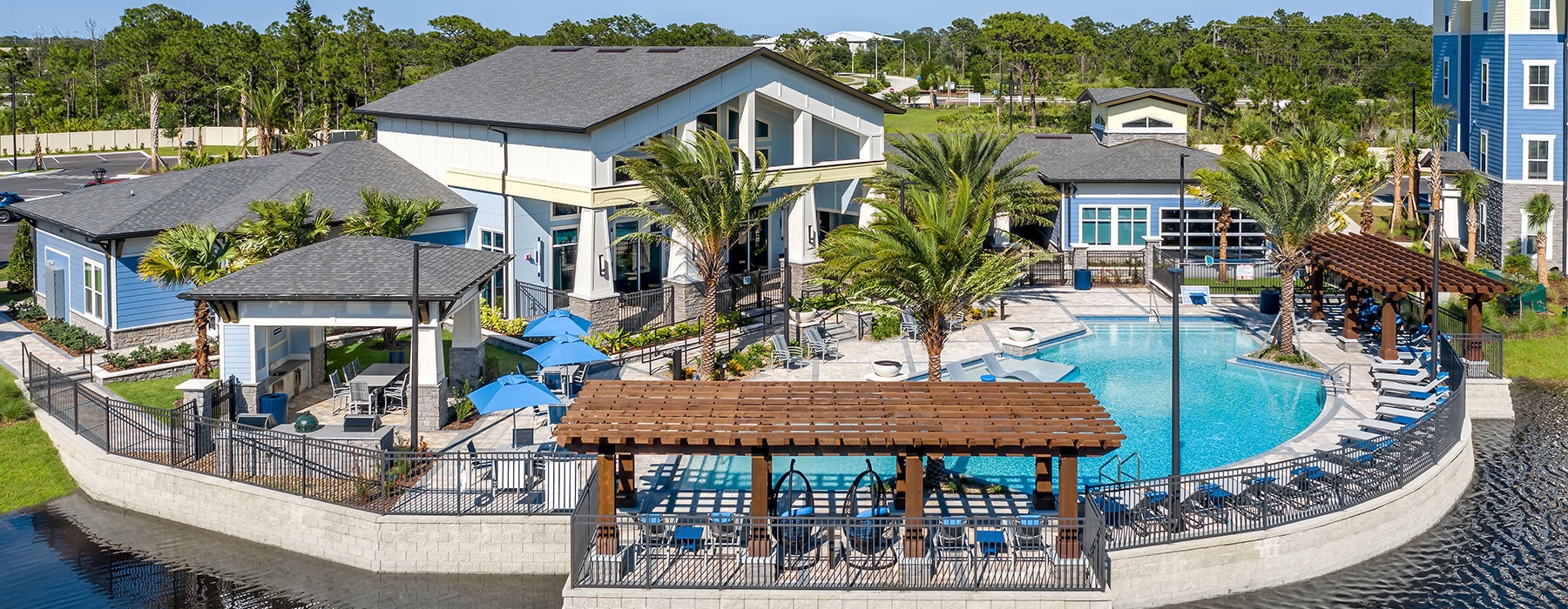 a resort style pool with seating and a building behind it